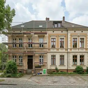 Denkmalgeschütztes Wohngebäude mit historischer Fassade während energetischer Sanierung mit Gerüst